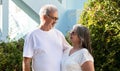 Smiling old european husband and wife in white t-shirts hugging, enjoy spare time, outdoors Royalty Free Stock Photo