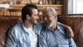 Smiling old father and adult son enjoy family weekend Royalty Free Stock Photo