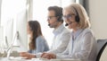 Smiling old female call center agent in headset consulting client Royalty Free Stock Photo
