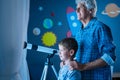 Grandfather and grandson looking out of the window at night Royalty Free Stock Photo