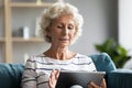 Smiling old senior retired woman using computer tablet. Royalty Free Stock Photo
