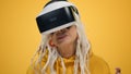 Smiling old woman watching film in vr glasses on yellow studio background. Royalty Free Stock Photo