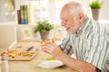 Smiling older man eating pizza slice Royalty Free Stock Photo