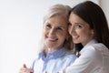 Smiling older mom and grownup daughter hugging