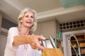 Smiling older woman in kitchen with knife block