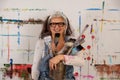 Smiling older woman, proud artist, in her fifties with grey hair and glasses and many paintbrushes Royalty Free Stock Photo