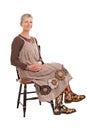 Smiling older woman sits in flowered boots Royalty Free Stock Photo