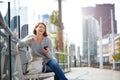Smiling older woman sitting outside with mobile phone Royalty Free Stock Photo