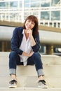 Smiling older woman sitting on steps outside Royalty Free Stock Photo