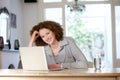 Smiling older woman sitting at table using laptop Royalty Free Stock Photo