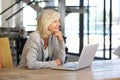 Smiling older woman working laptop computer indoors Royalty Free Stock Photo