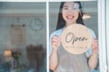 Smiling online small business owner holding a sign saying Open and happily working at a courier business