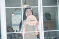 Smiling online small business owner holding a sign saying Open and happily working at a courier business