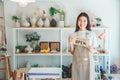 Smiling online small business owner holding a sign saying Open and happily working