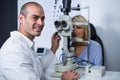 Smiling optometrist examining female patient on slit lamp Royalty Free Stock Photo