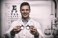 Smiling optometrist holding messbrille