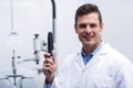 Smiling optometrist holding ophthalmoscope Royalty Free Stock Photo