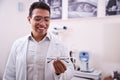 Smiling optometrist looking at prescription eyewear in his hand Royalty Free Stock Photo