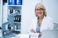 Smiling optometrist sitting with arms crossed