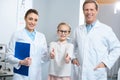 smiling optometrists and little kid in eyeglasses showing