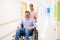 Female Healthcare Worker With Patient On Wheelchair At Hospital