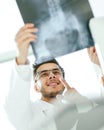 Smiling orthopedist doctor looks at the x - ray of the patient Royalty Free Stock Photo