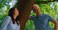 Smiling pair standing on nature closeup . Happy couple relax lean on tree trunk. Royalty Free Stock Photo