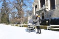 Mother with baby by riding-school of Palace Hluboka during winter