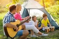 Smiling parent and children enjoying on camping