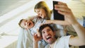 Smiling parents with baby taking selfie family photo on bed at home Royalty Free Stock Photo