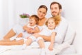 Smiling parents on bed with two adorable children Royalty Free Stock Photo