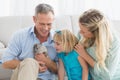 Smiling parents and daughter sitting with rabbit together Royalty Free Stock Photo