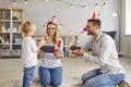 Happy mom and dad looking at their little son studying his new toy he got as birthday present Royalty Free Stock Photo