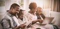 Parents and kids using laptop and digital tablet on sofa Royalty Free Stock Photo