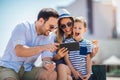 Smiling parents and little boy with tablet pc and credit card