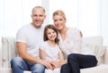 Smiling parents and little girl at home