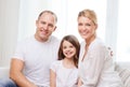 Smiling parents and little girl at home