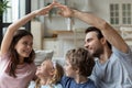 Smiling parents sitting with kids, making roof gesture with hands