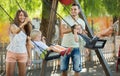 Smiling parents swinging children