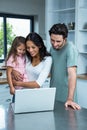 Smiling parents using laptop with daughter Royalty Free Stock Photo