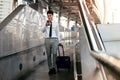 Smiling  Passenger Businessman Using Mobile Phone while Walking with Suitcase in the Airport or Public Transportation Station Royalty Free Stock Photo