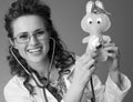 Smiling pediatrist woman listening toy with stethoscope on