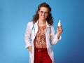 Smiling pediatrist woman showing nasal drops on blue Royalty Free Stock Photo