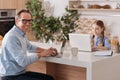 Smiling pensioner and kid using modern laptops at home