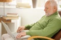 Smiling pensioner using laptop computer