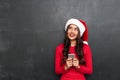 Smiling pensive brunette woman in red blouse and christmas hat Royalty Free Stock Photo