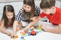 Smiling pensive children of boy and girls connect colorful chain figures, make puzzle constructor. Children development Royalty Free Stock Photo