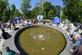 Smiling people enjoying spring sunny day playing with children near fountain at the park Royalty Free Stock Photo