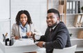 Smiling personnel manager and successful vacancy candidate drinking coffee during job interview at office