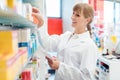 Pharmacist or Chemist woman sorting drugs in shelves in her pharmacy